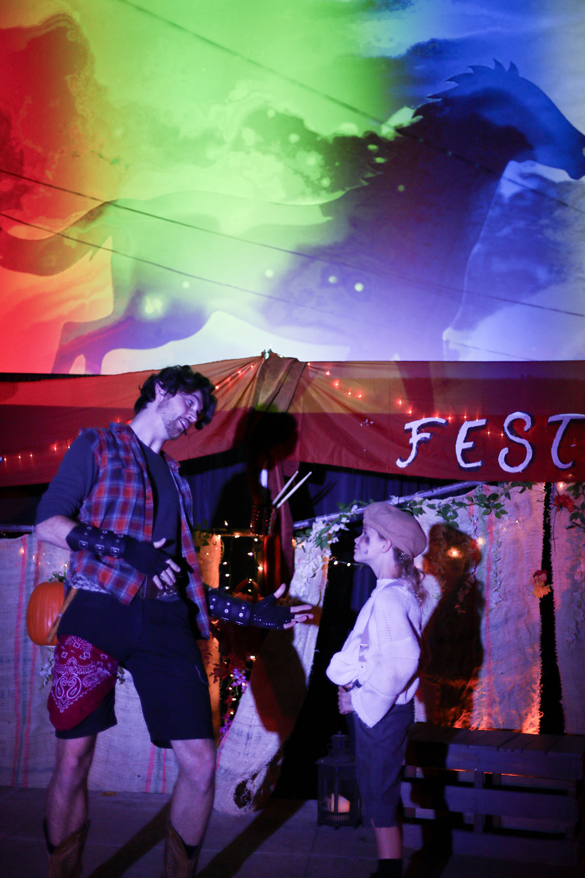 David Hintz and Jane Curry face each other at the Fall Festival, the horse projection glowing above