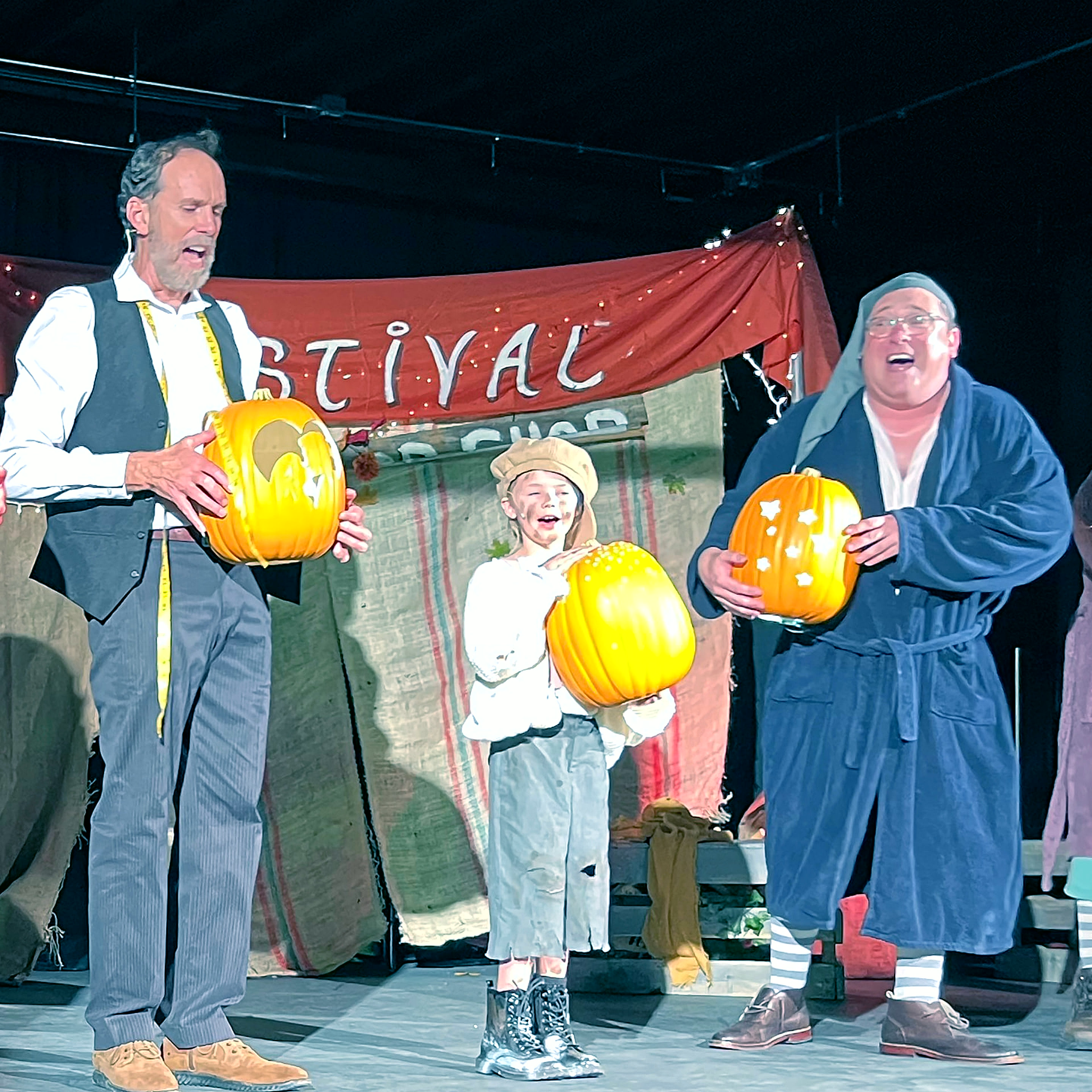 Find A Light: Rob Utesch, Jane Curry and Bryan Plummer hold carved pumpkins beneath the Fall Festival banner