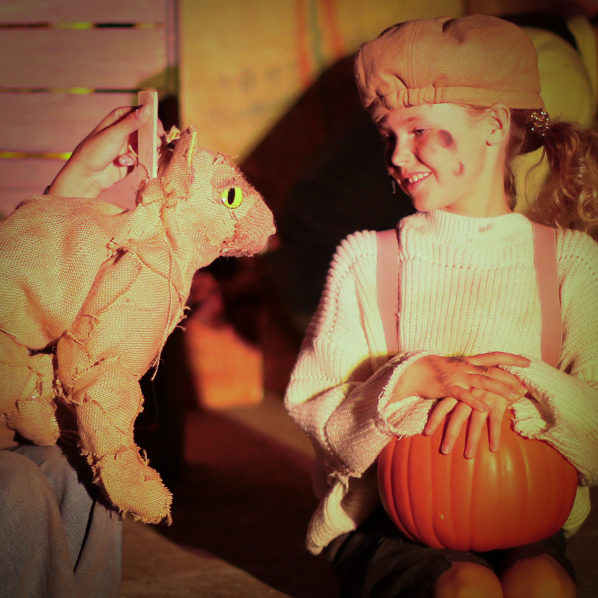 Jane Curry as the Pumpkin Kid smiling at Pluck, the burlap cat puppet